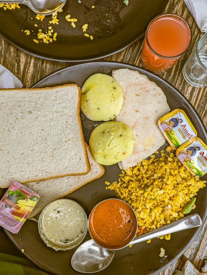 A classic Indian breakfast served with bread, idli, and vibrant sauces for a flavorful meal.