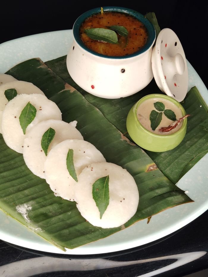 The Art of Drawing Readers In: Your attractive post title goes here Delicious South Indian idli served on banana leaves with sambar and coconut chutney.